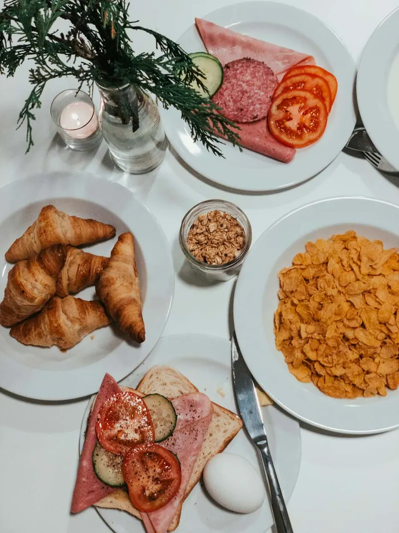 Tavola con brioche, salumi e frutta